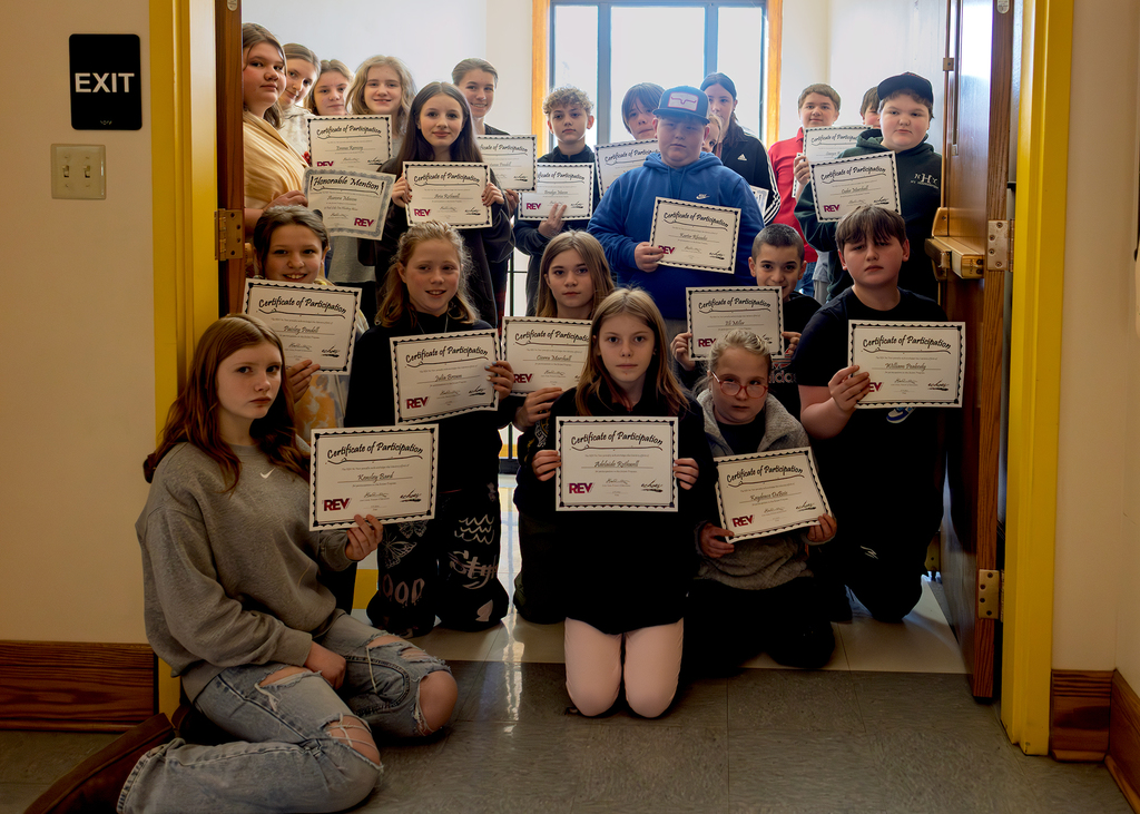 Students holding certificates in the hallway