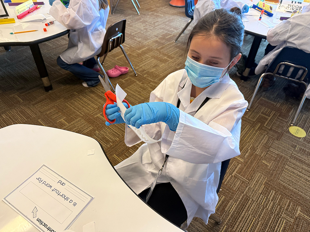 A first grade student performs contraction surgery