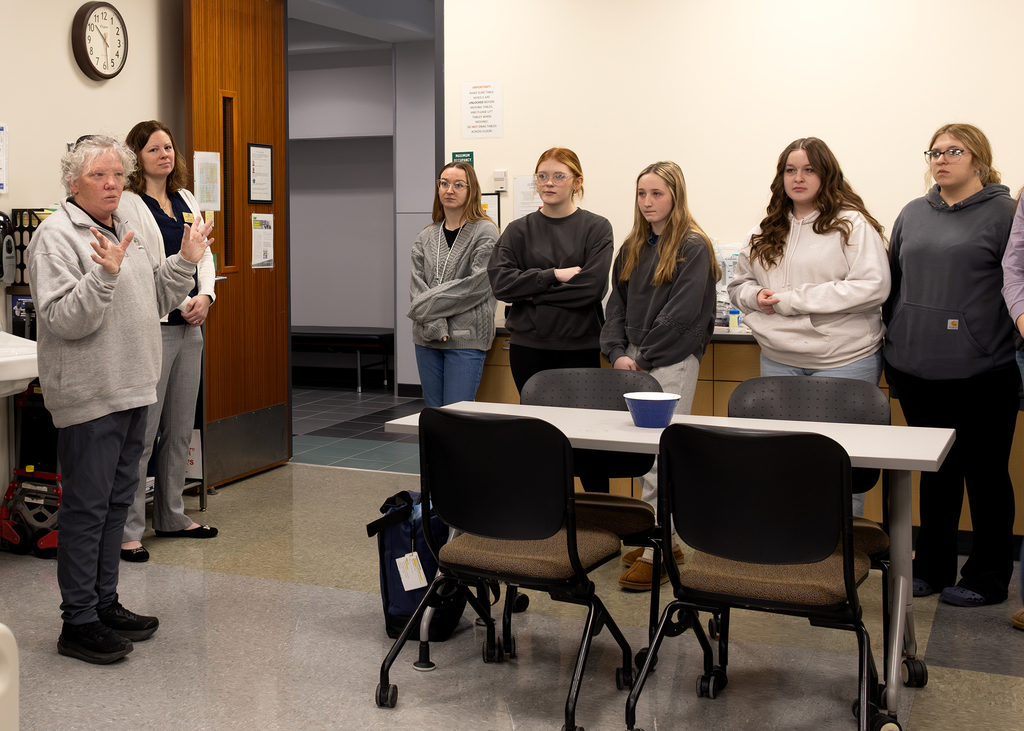 Students listen to a nursing instructor