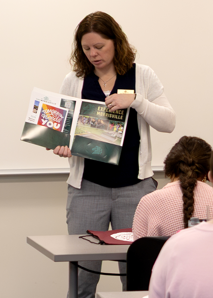 The  director of the SUNY Morrisville Norwich Branch Campus speaks to students in the classroom and shares what is in their folders
