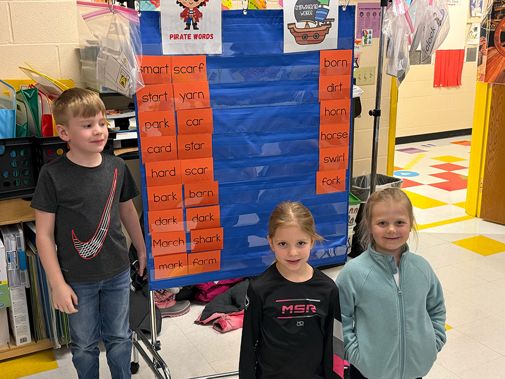 Students stand near the list of AR words