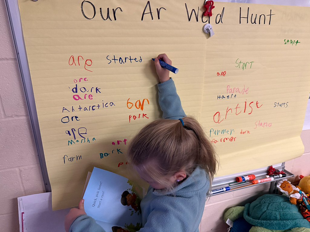 A student writes an AR word on the board