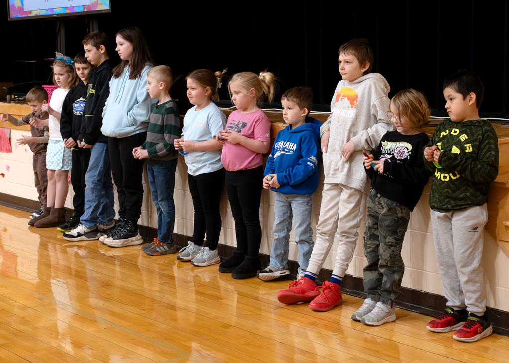Students stand near the stage
