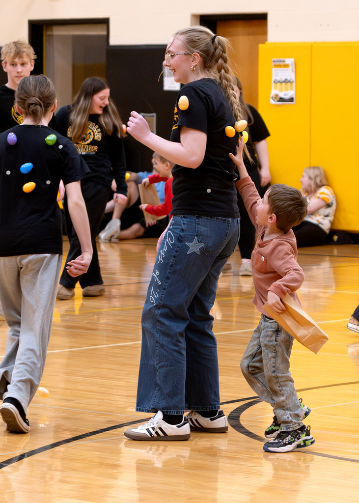 A PreK student finds an egg on a student government student's back