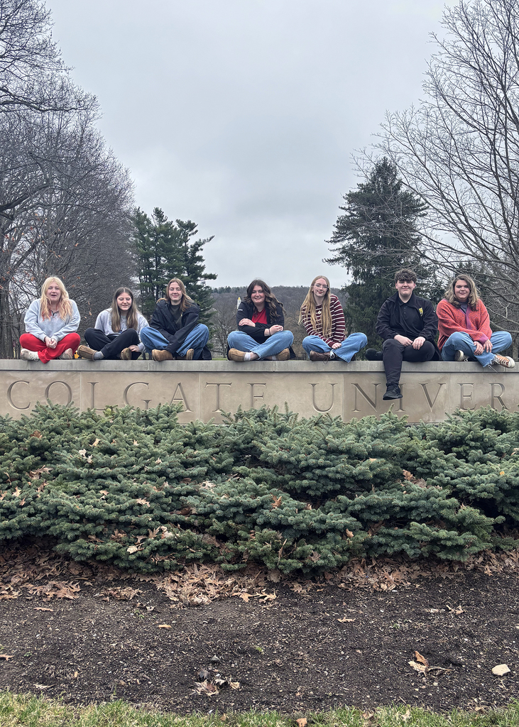 Students sitting on the Colgate University sign