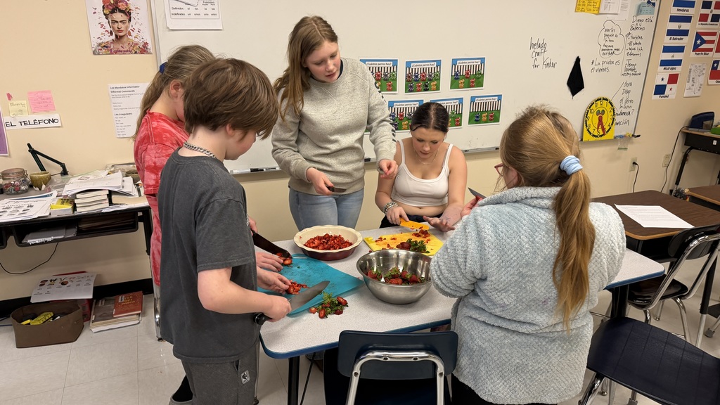 Students in a 6th grade cooking class prepare and assemble chocolate strawberry dessert cups 