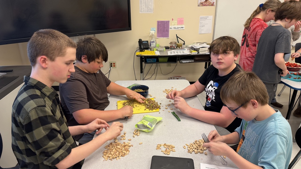 Students in a 6th grade cooking class prepare and assemble chocolate strawberry dessert cups 