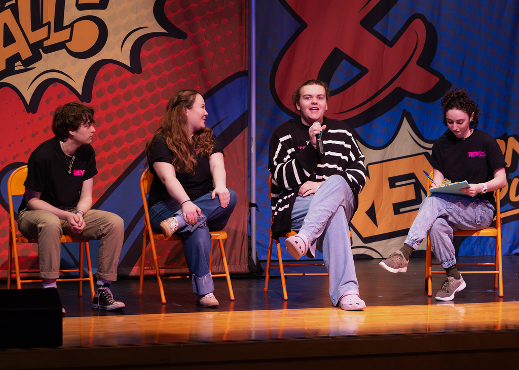 The REV cast on stage performing with an OV student