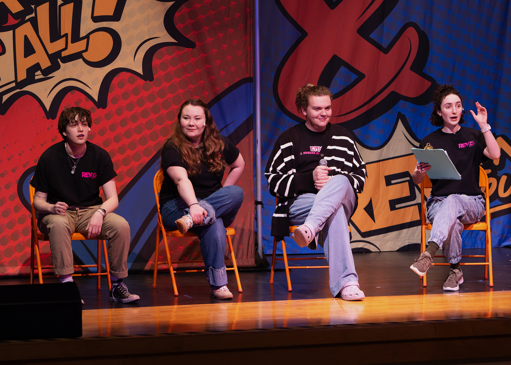 The REV cast on stage performing with an OV student