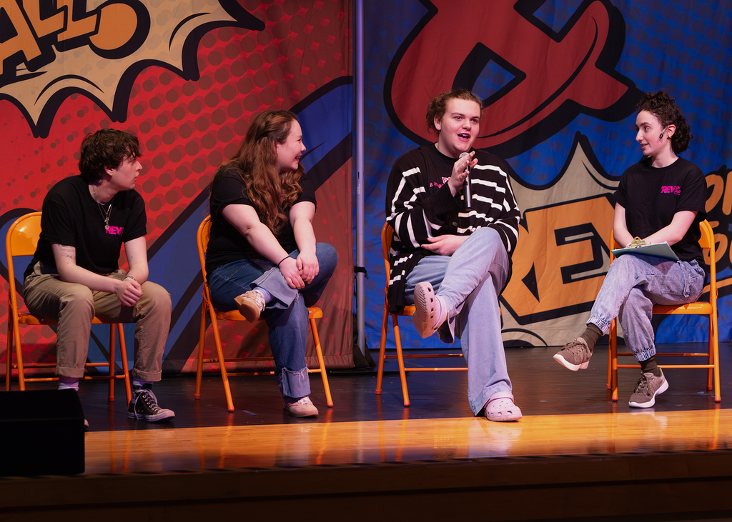 The REV cast on stage performing with an OV student