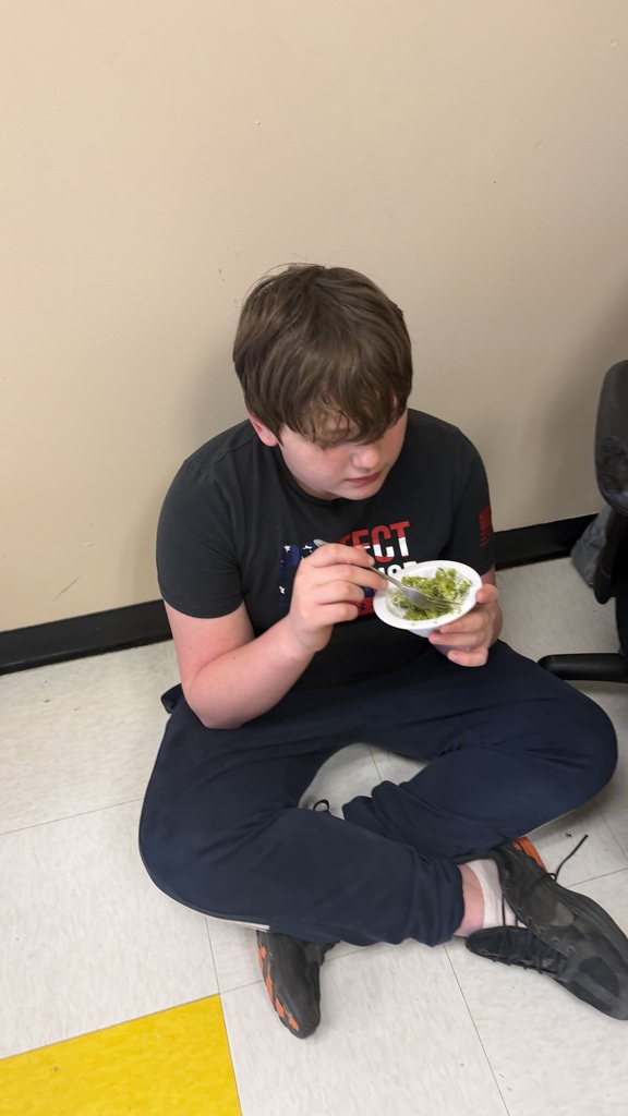 Student sits on floor eating bowl of ramp pesto pasta.Student sits on floor eating bowl of ramp pesto pasta.
