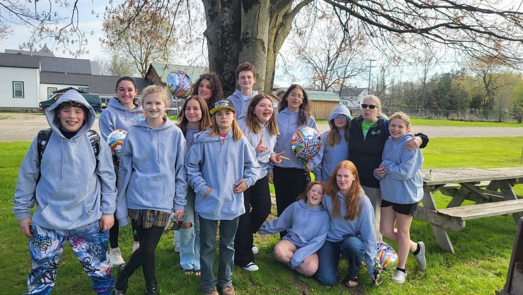 Group of Otselic Valley students and SUNY Morrisville Liberty Partnerships Program mentors standing outdoors under a large tree, smiling for a group photo