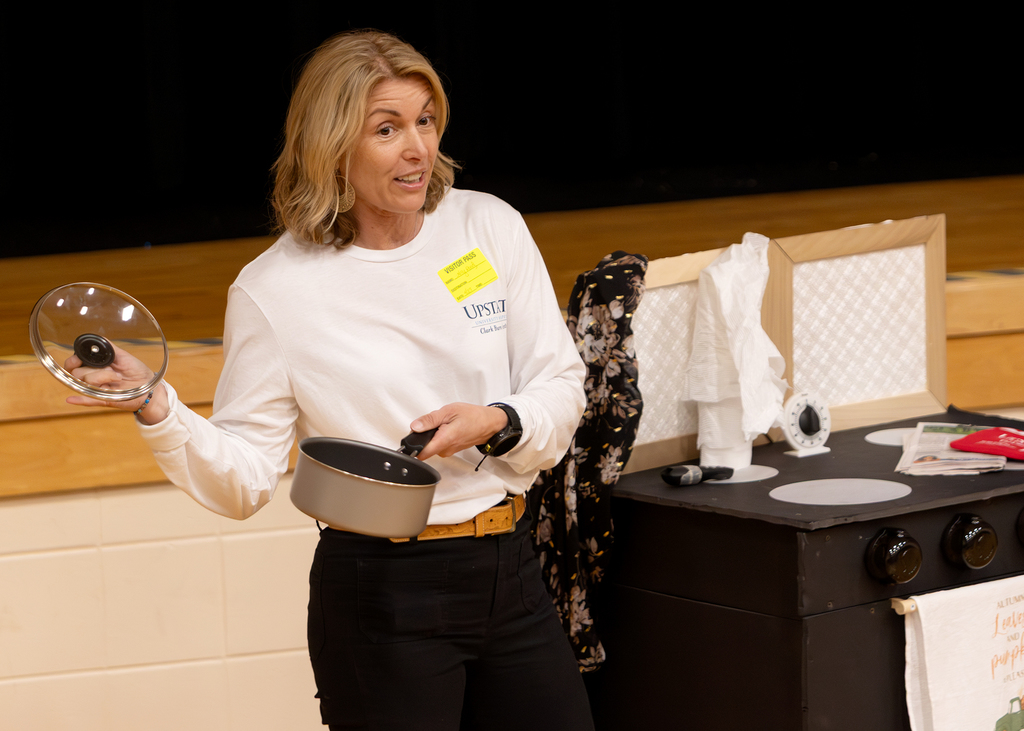 Guest presenter uses kitchen items as props while discussing cooking and stove safety.