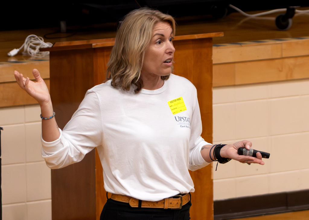 Guest presenter speaks to students in the school auditorium during a fire and burn safety presentation.