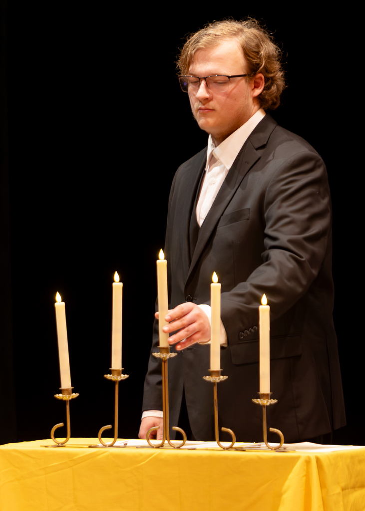 A student places a candle on the table