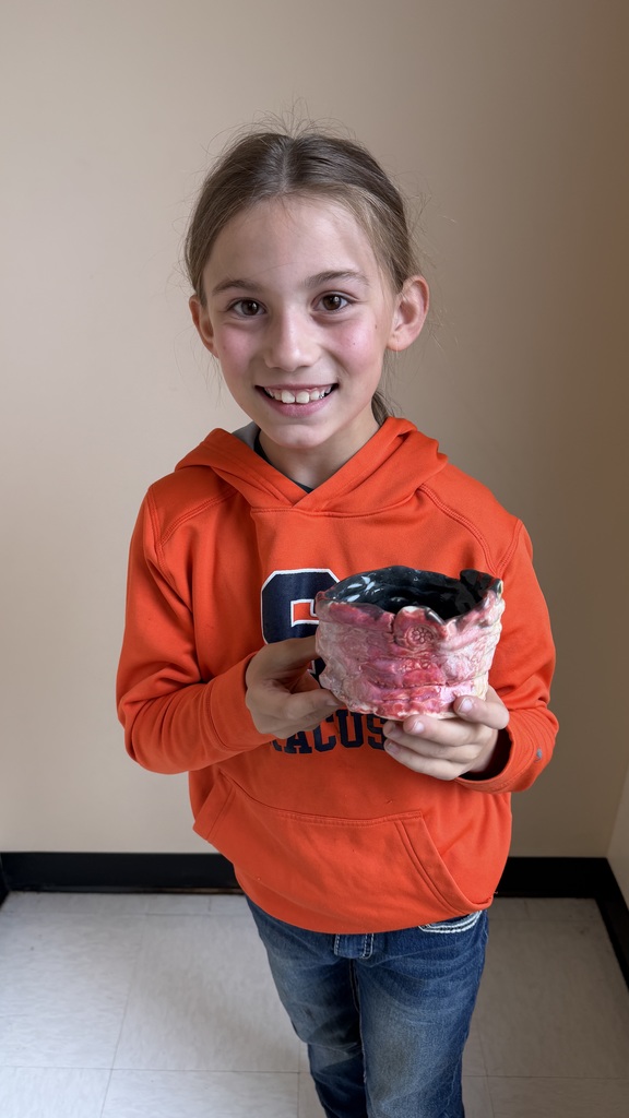 Finished glazed clay coil pots created by fourth grade students, displayed after completion of the classroom art project.
