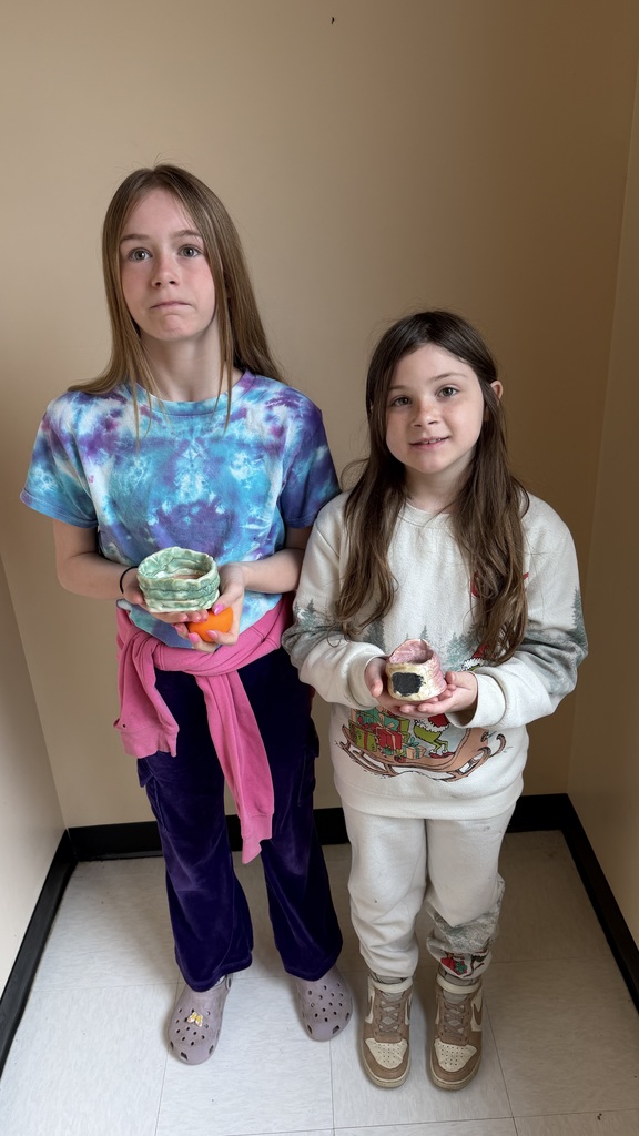 Finished glazed clay coil pots created by fourth grade students, displayed after completion of the classroom art project.