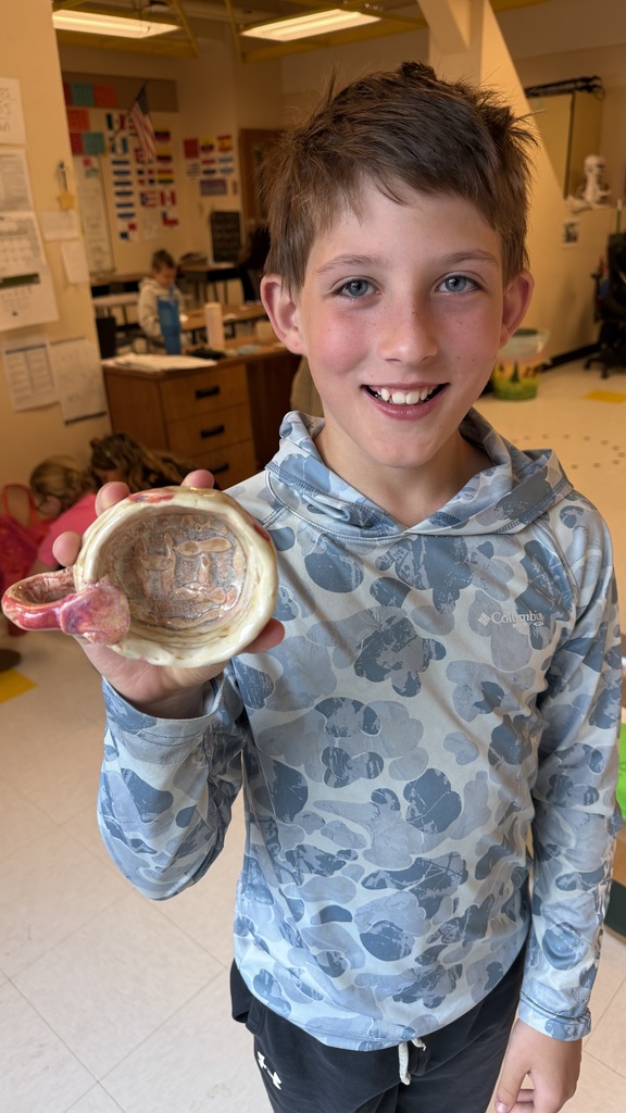 Finished glazed clay coil pots created by fourth grade students, displayed after completion of the classroom art project.