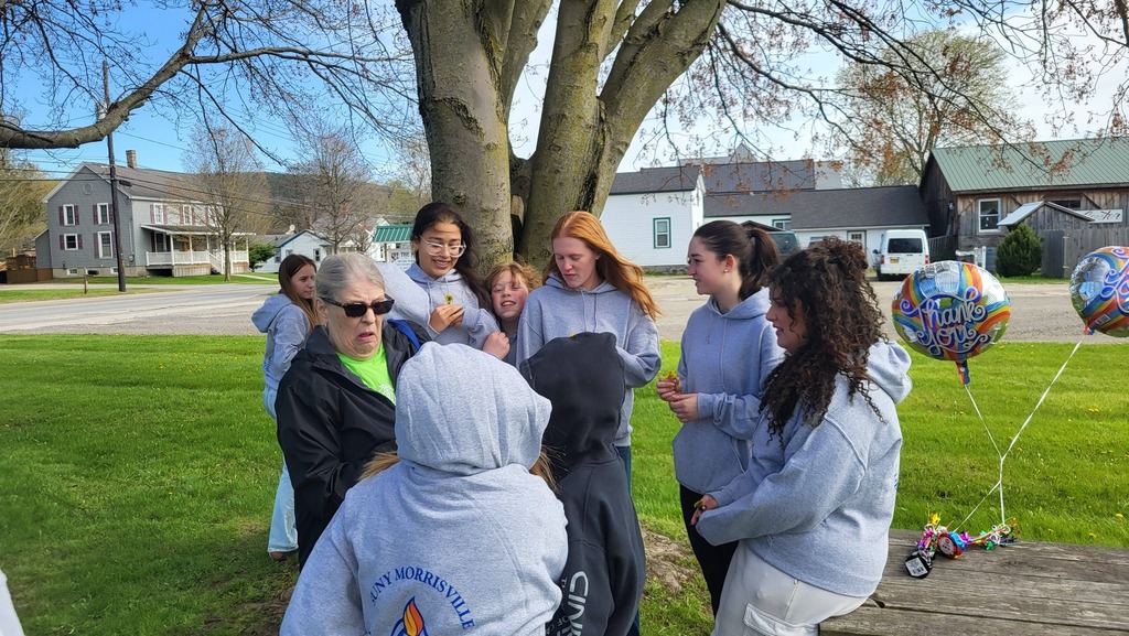 OV students and Colgate mentors gather outdoors for an end-of-year celebration, spending time together and smiling.