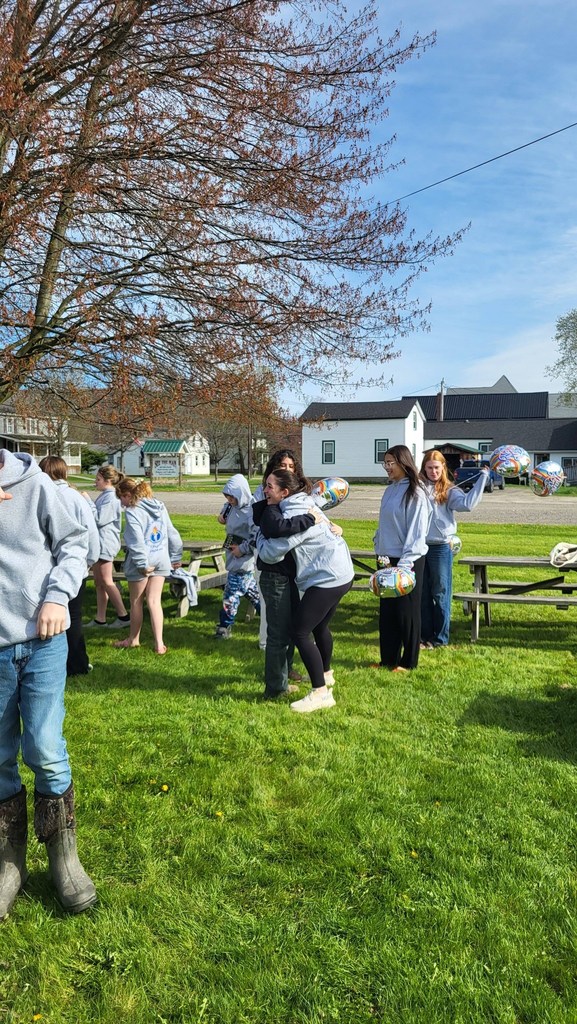 OV students and Colgate mentors gather outdoors for an end-of-year celebration, spending time together and smiling.