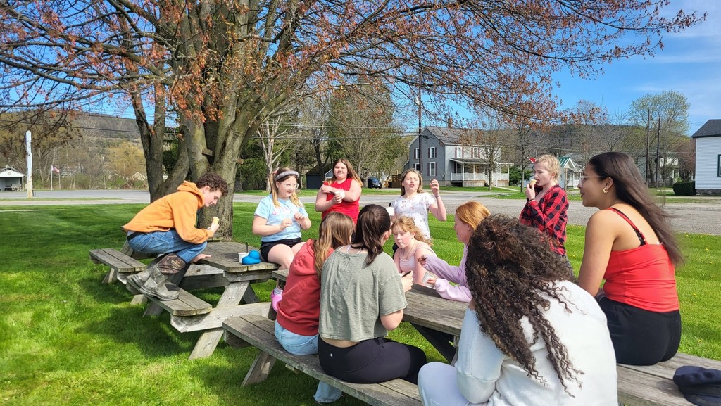 OV students and Colgate mentors gather outdoors for an end-of-year celebration, spending time together and smiling.