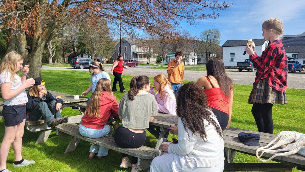 OV students and Colgate mentors gather outdoors for an end-of-year celebration, spending time together and smiling.