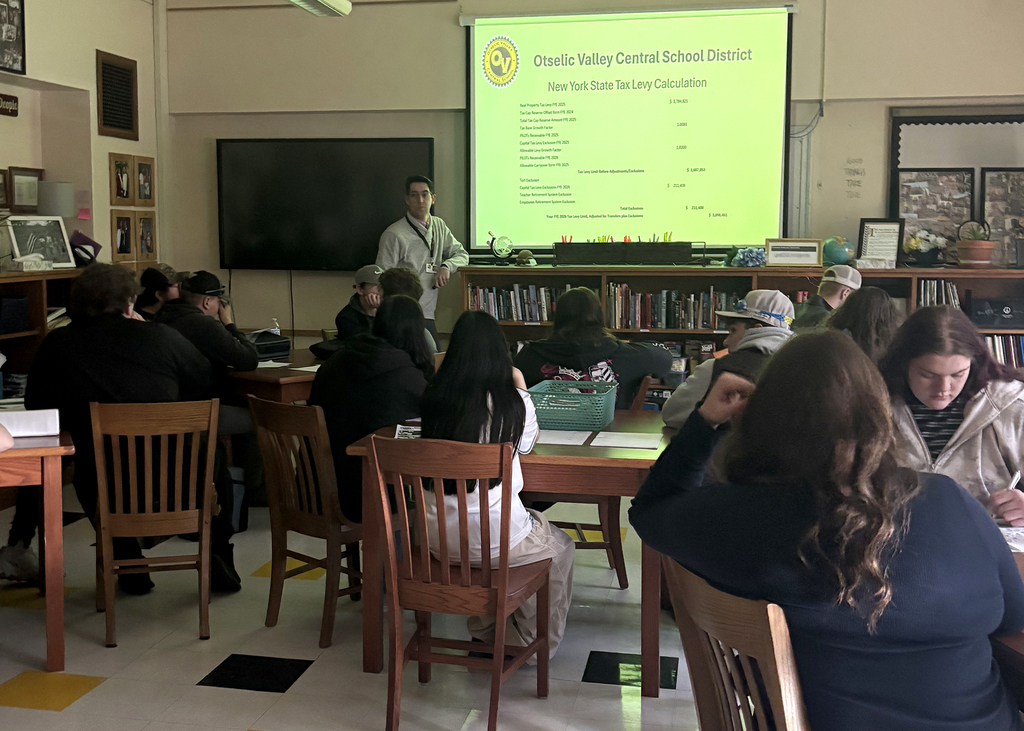 OV seniors sit in Mrs. Osowski’s economics class while district administrators discuss the proposed school budget and tax levy calculation using a presentation screen at the front of the room.