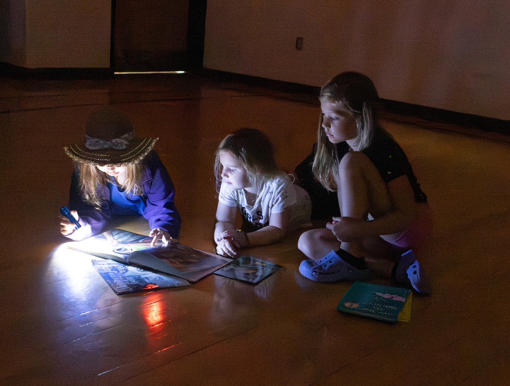Kindergarten through second grade students participate in Flashlight Reading as part of the ABC Countdown to Summer, using flashlights while reading together with classmates.
