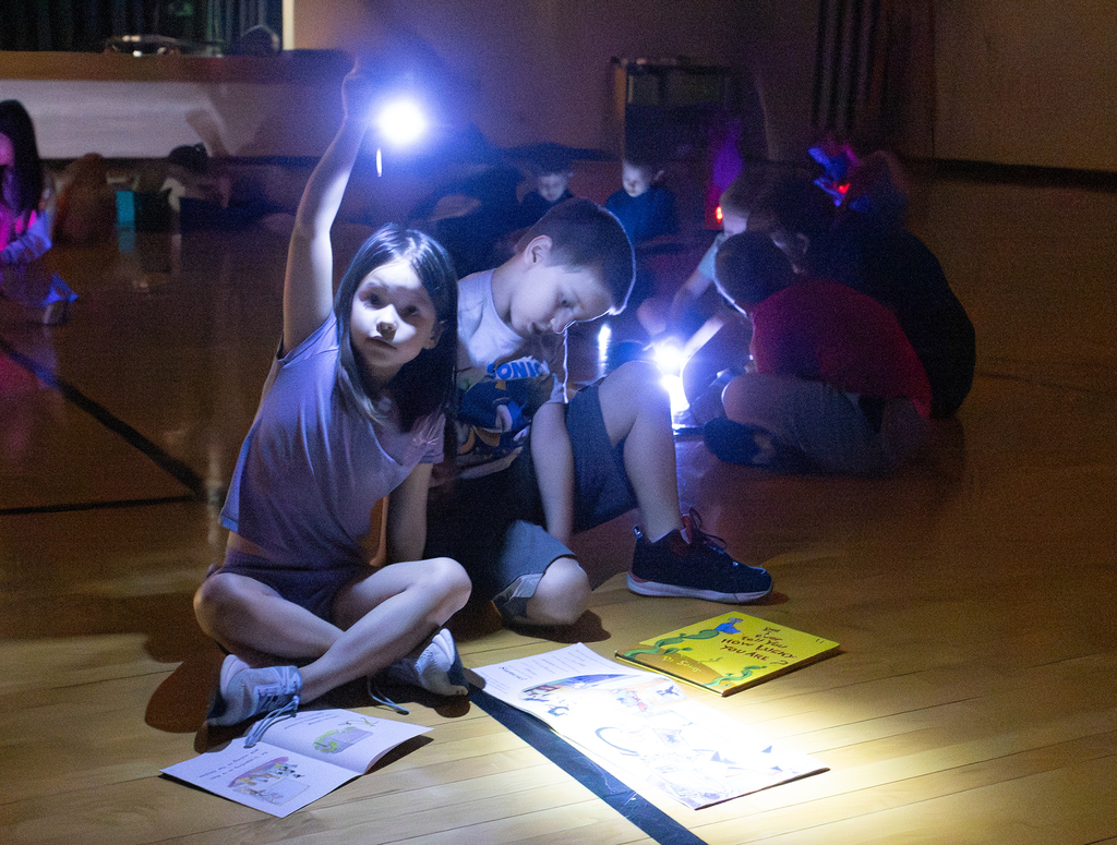 Kindergarten through second grade students participate in Flashlight Reading as part of the ABC Countdown to Summer, using flashlights while reading together with classmates.