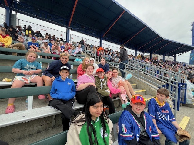 Students and staff attending a Syracuse Mets game during an OV incentive trip. Photos show students at the ballpark, in the stands, and enjoying the day together.