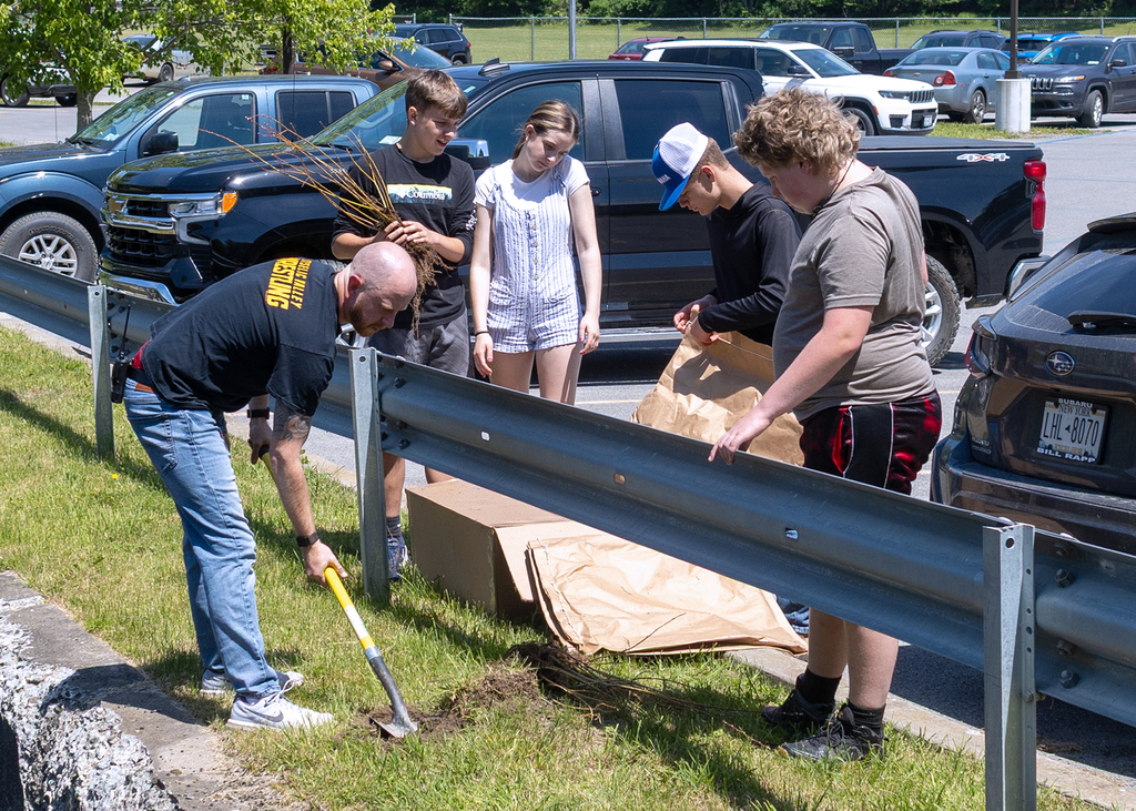 Middle school students plant young willow trees along the bank of Ashbell Brook near Otselic Valley school property as part of an erosion prevention and environmental stewardship project.