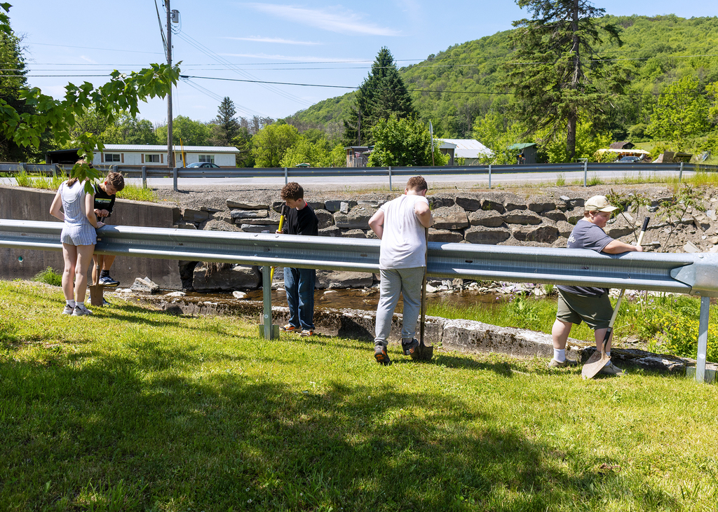 Middle school students plant young willow trees along the bank of Ashbell Brook near Otselic Valley school property as part of an erosion prevention and environmental stewardship project.