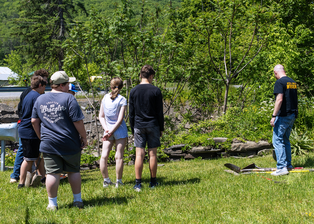 Middle school students plant young willow trees along the bank of Ashbell Brook near Otselic Valley school property as part of an erosion prevention and environmental stewardship project.