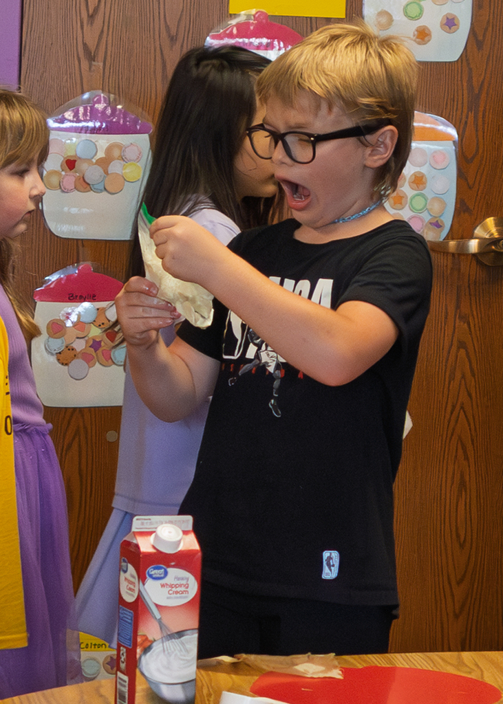 Mrs. Marston's second grade students work together to make homemade ice cream with Mr. Harvey. Students take turns helping with the process and enjoy tasting the finished treat.