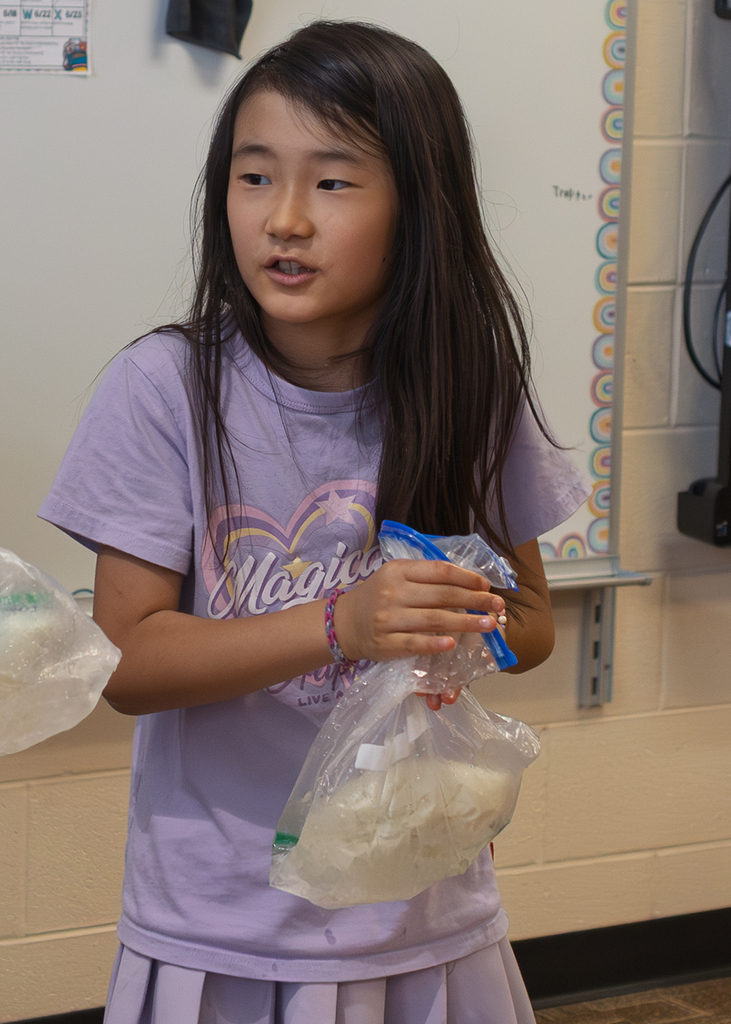 Mrs. Marston's second grade students work together to make homemade ice cream with Mr. Harvey. Students take turns helping with the process and enjoy tasting the finished treat.