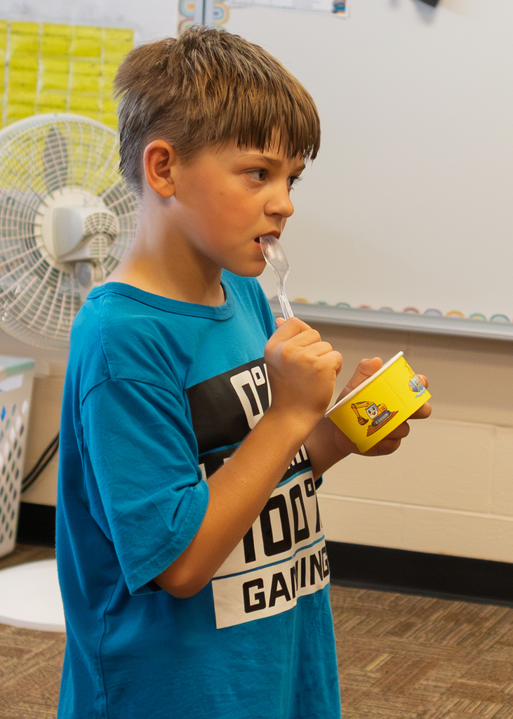 Mrs. Marston's second grade students work together to make homemade ice cream with Mr. Harvey. Students take turns helping with the process and enjoy tasting the finished treat.