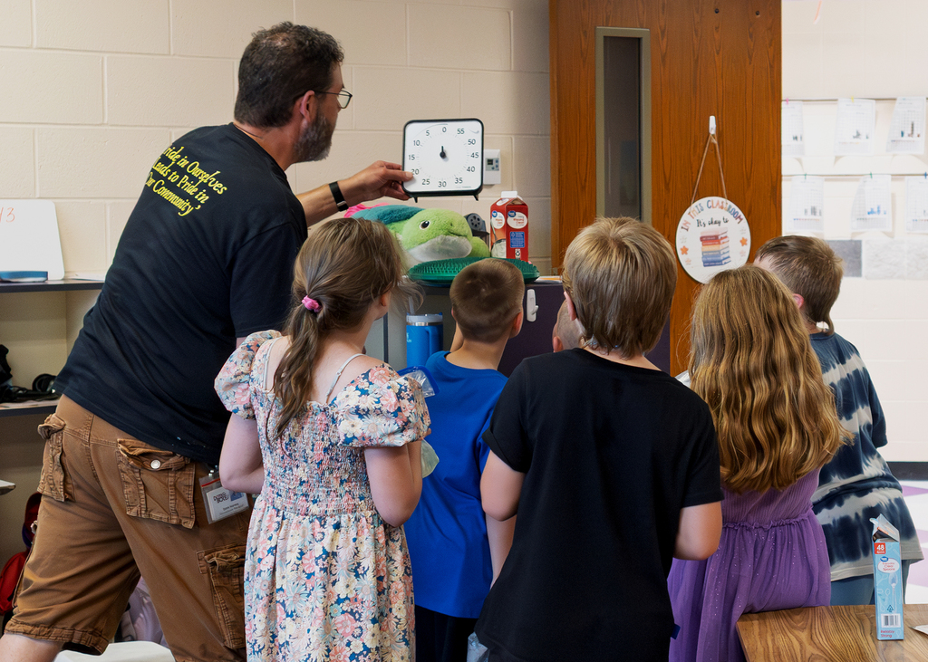 Mrs. Marston's second grade students work together to make homemade ice cream with Mr. Harvey. Students take turns helping with the process and enjoy tasting the finished treat.