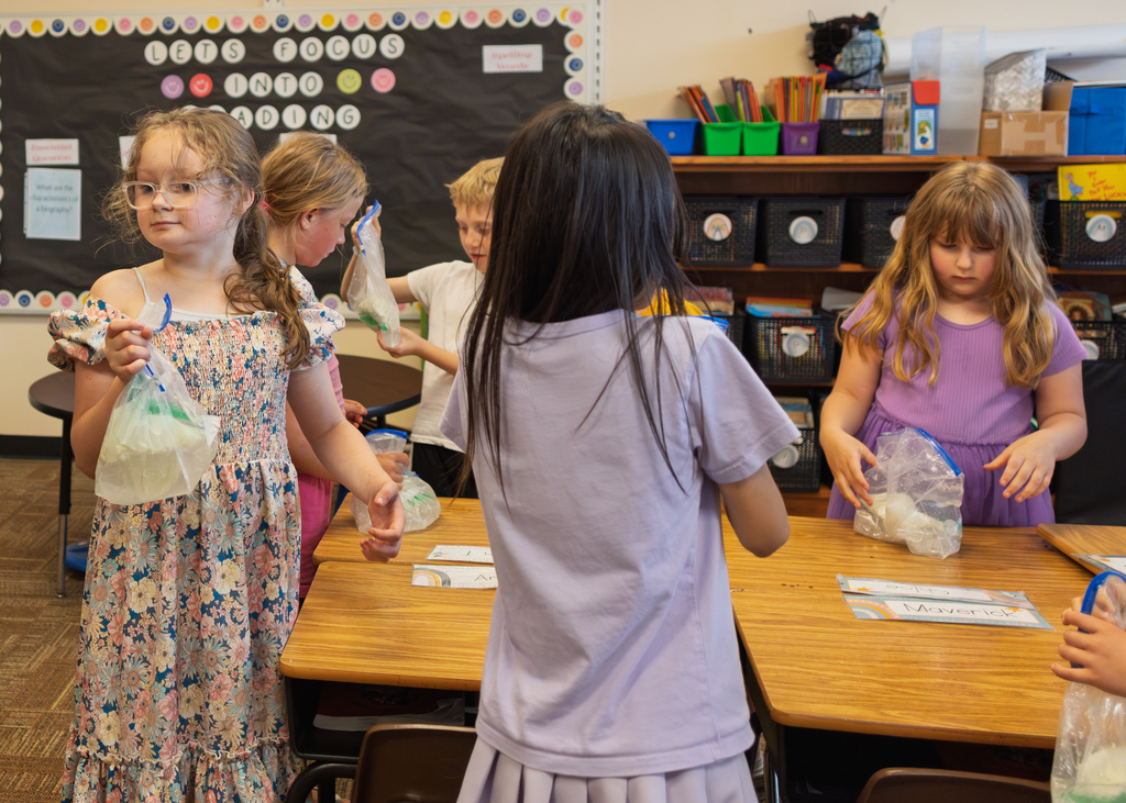 Mrs. Marston's second grade students work together to make homemade ice cream with Mr. Harvey. Students take turns helping with the process and enjoy tasting the finished treat.