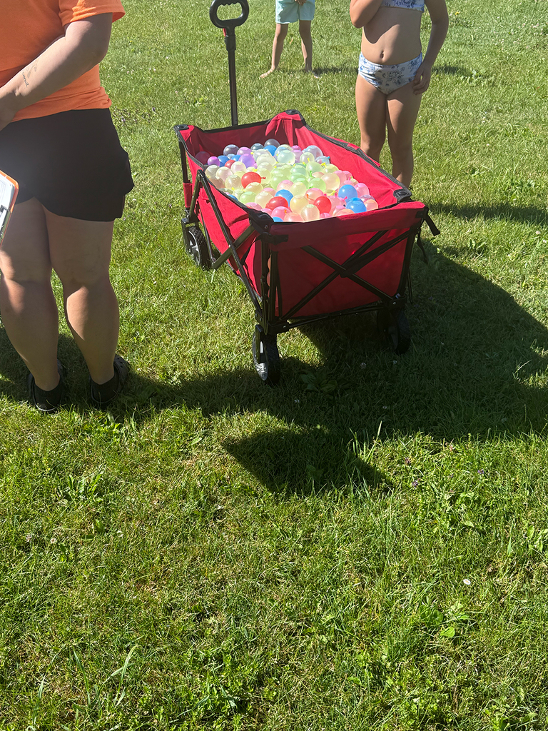 Elementary students enjoy Water Day outdoors, celebrating the end of the school year with fun activities and water balloons.