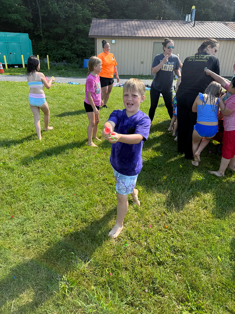 Elementary students enjoy Water Day outdoors, celebrating the end of the school year with fun activities and water balloons.