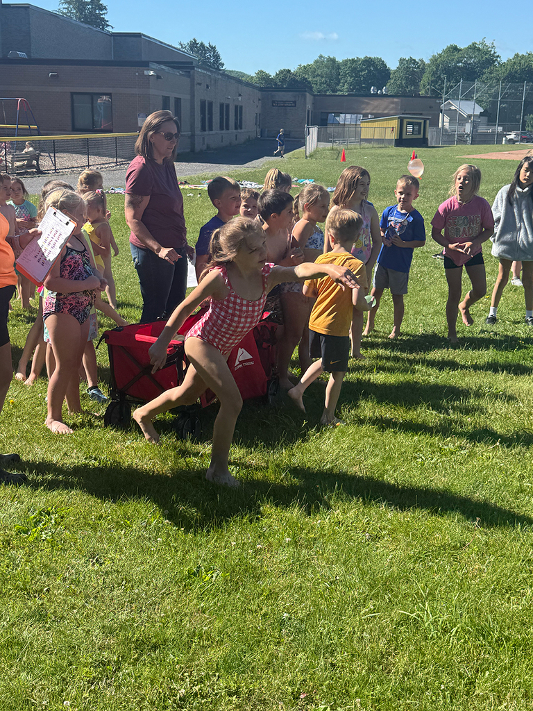 Elementary students enjoy Water Day outdoors, celebrating the end of the school year with fun activities and water balloons.