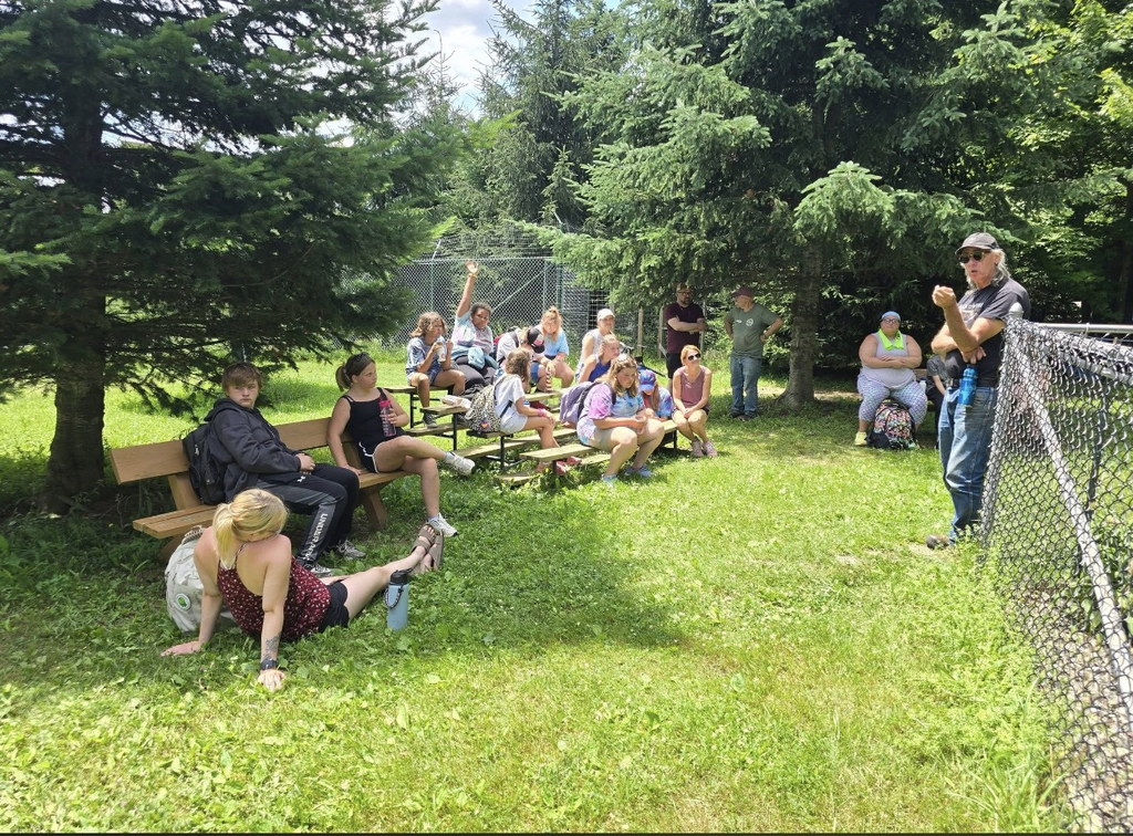 A group of students sitting with an adult standing