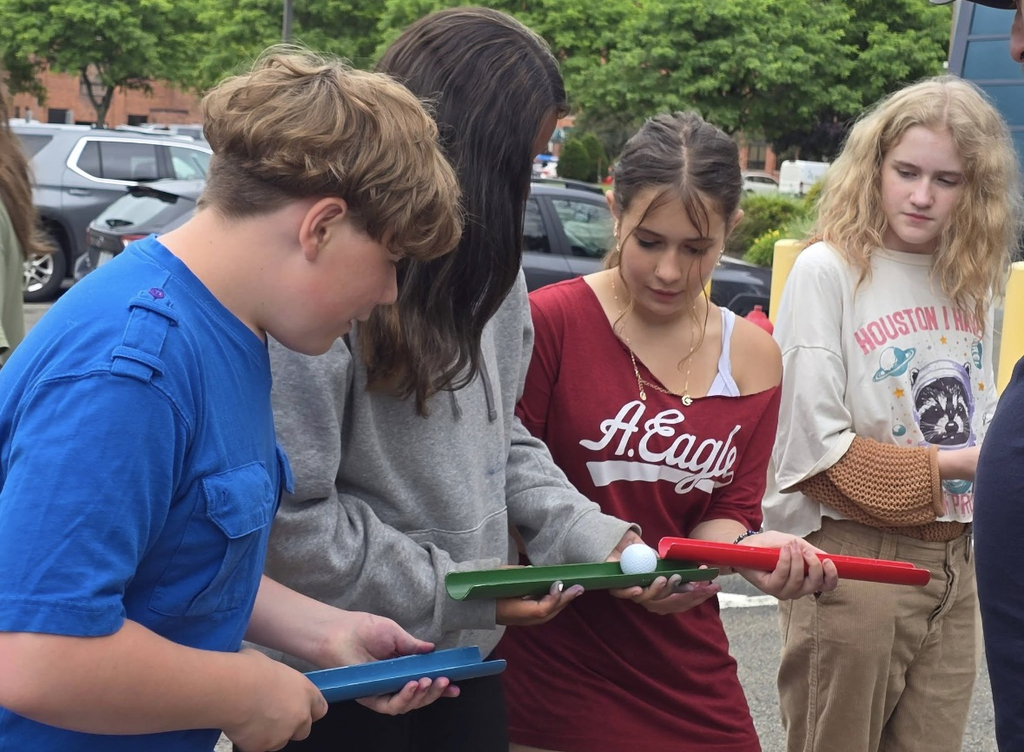 Students holding trays passing a small ball to each other