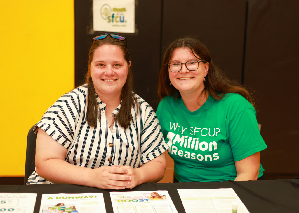 Two women from SFCU sitting at a black table