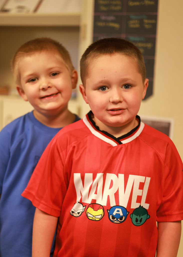 Two young students stand and smile