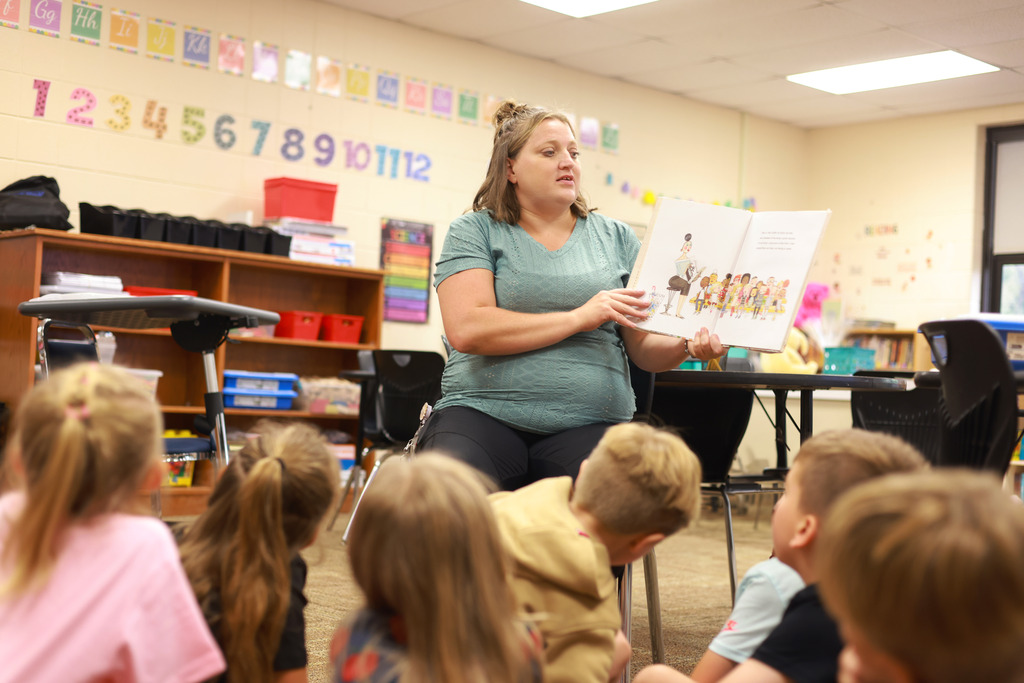 Teacher reads book to young students