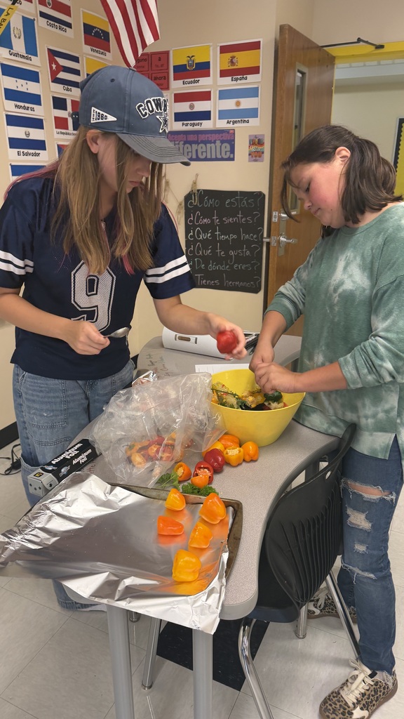 Two students standing over a bowl of peppers