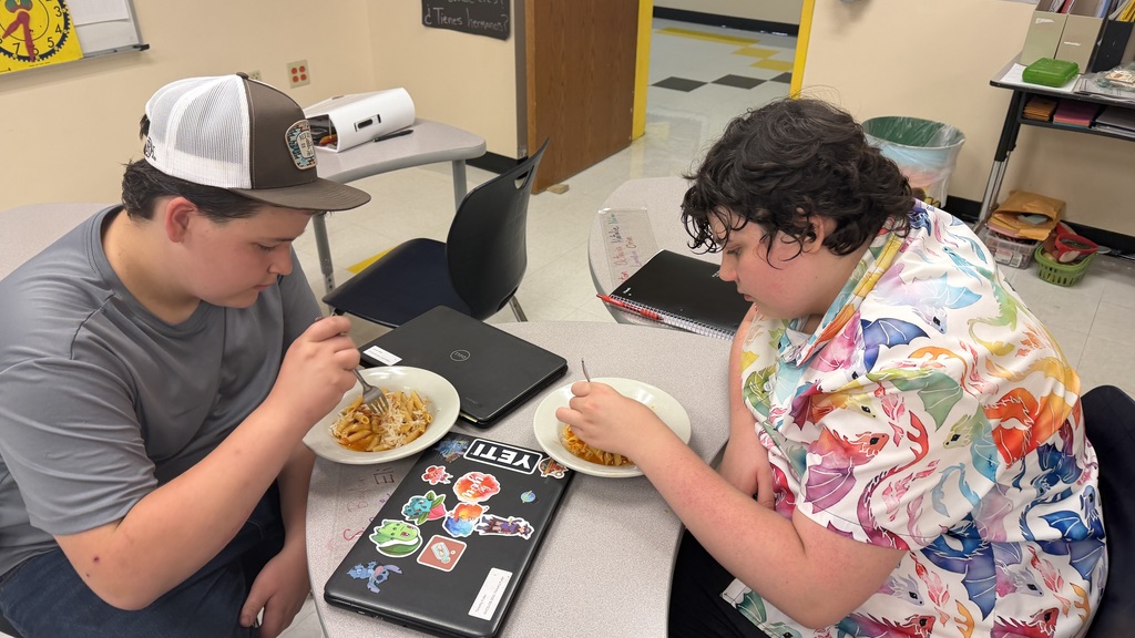 Two students sitting with pasta