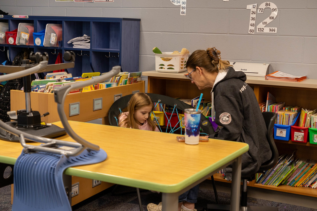 Student reading to teacher.