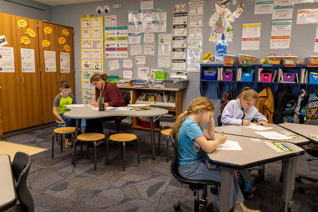 Kids working alone and with the help of a teacher.
